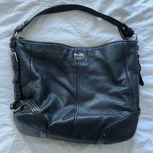 Super cute black coach purse if with pinkish purple inside.